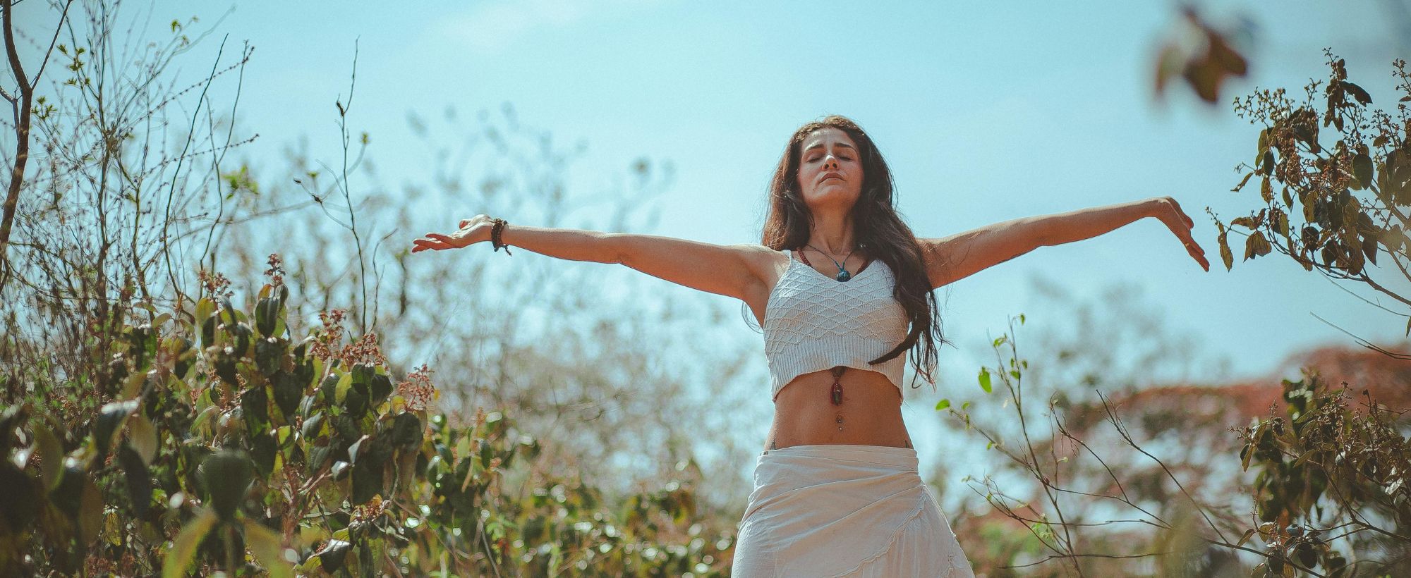 femme bras ouvert qui ferme les yeux et qui respire