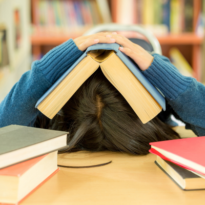 jeune avec un livre ouvert sur la tête, stress examen